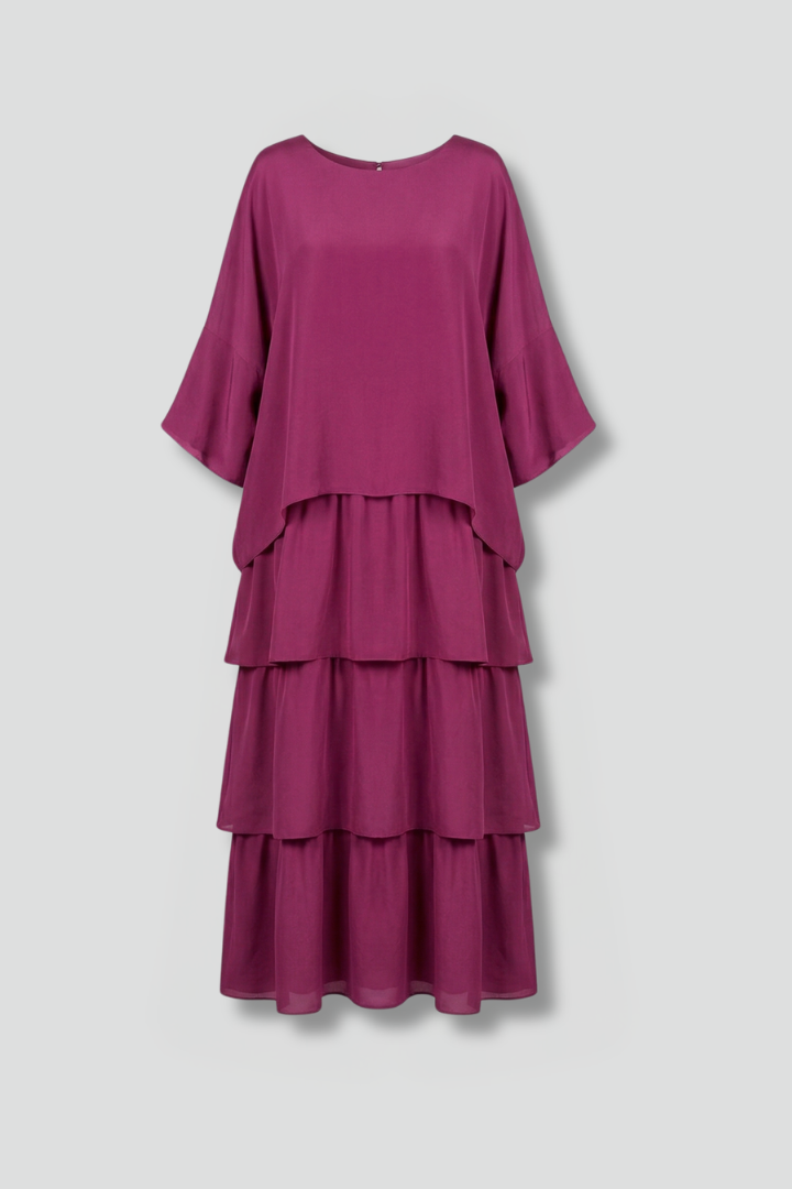 Ankle length tiered dress with round neckline on a plain background.