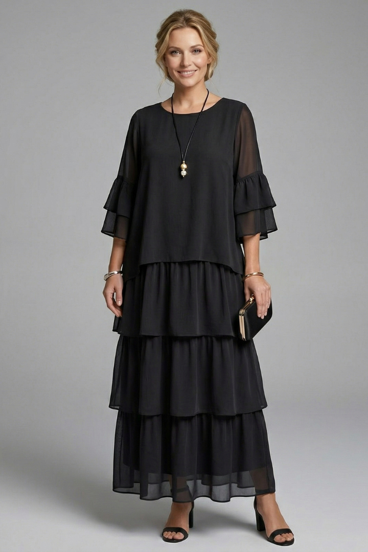 Model in a casual round neck maxi dress with short wide sleeves on a plain background.