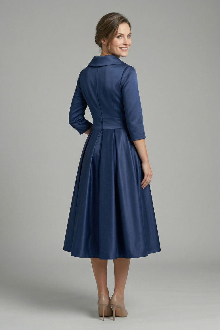 Woman wearing a long sleeve midi dress with fitted waist and wrap front on a plain background.