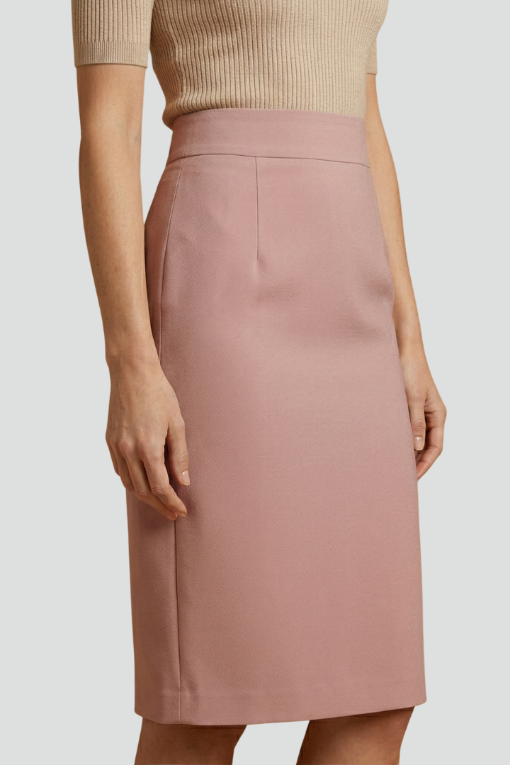 Female model showing a below knee skirt with a clean waistline and rear slit on a plain background.