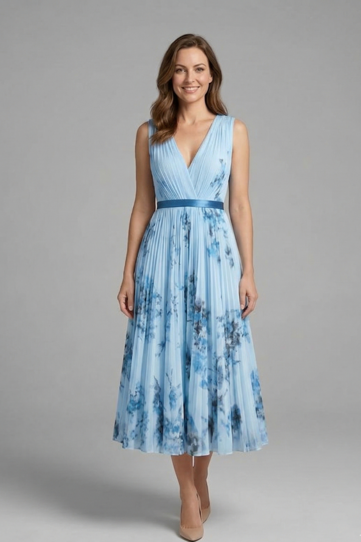 Female model styled in a sleeveless printed dress with a fitted waist and flowing silhouette.