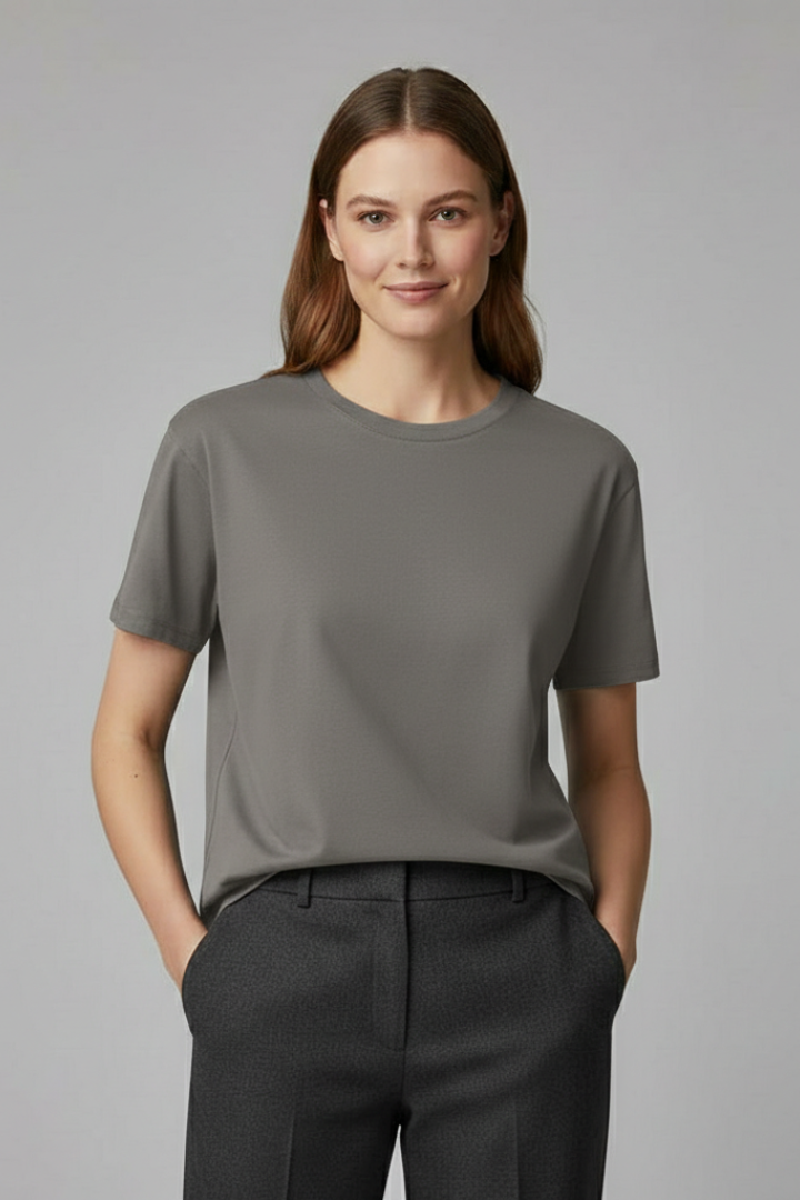 Women’s loose short sleeve T-shirt with below-hip length on a plain background.