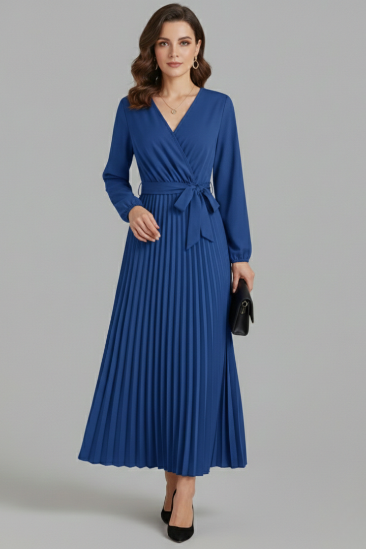 Female model in a long pleated dress with a tie waist and relaxed puff sleeves.