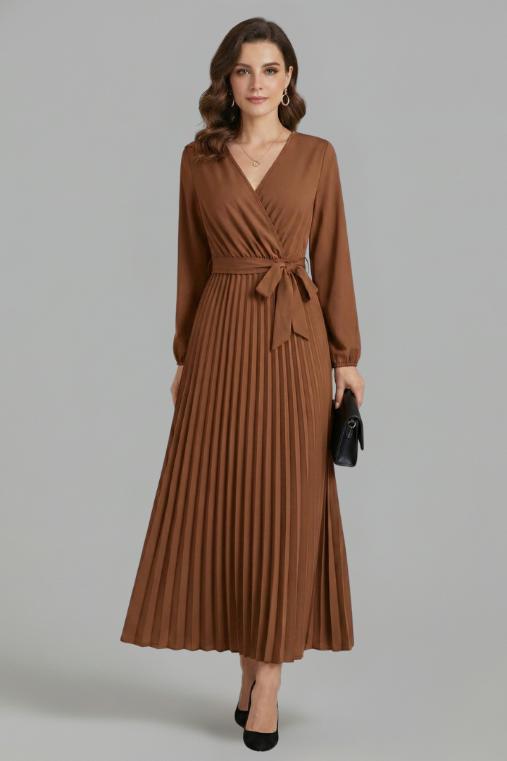 Female model wearing a long sleeve maxi dress with a fitted waist and flowing skirt.