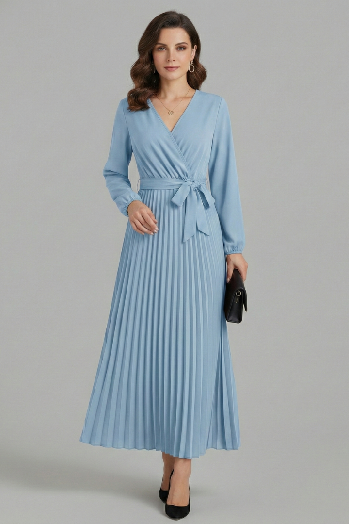 Woman wearing a long dress with pleated details and an adjustable waist tie.