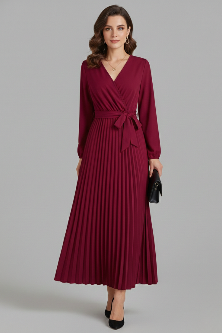 Female model wearing a V-neck maxi dress with a pleated skirt and tie waist against a plain background.