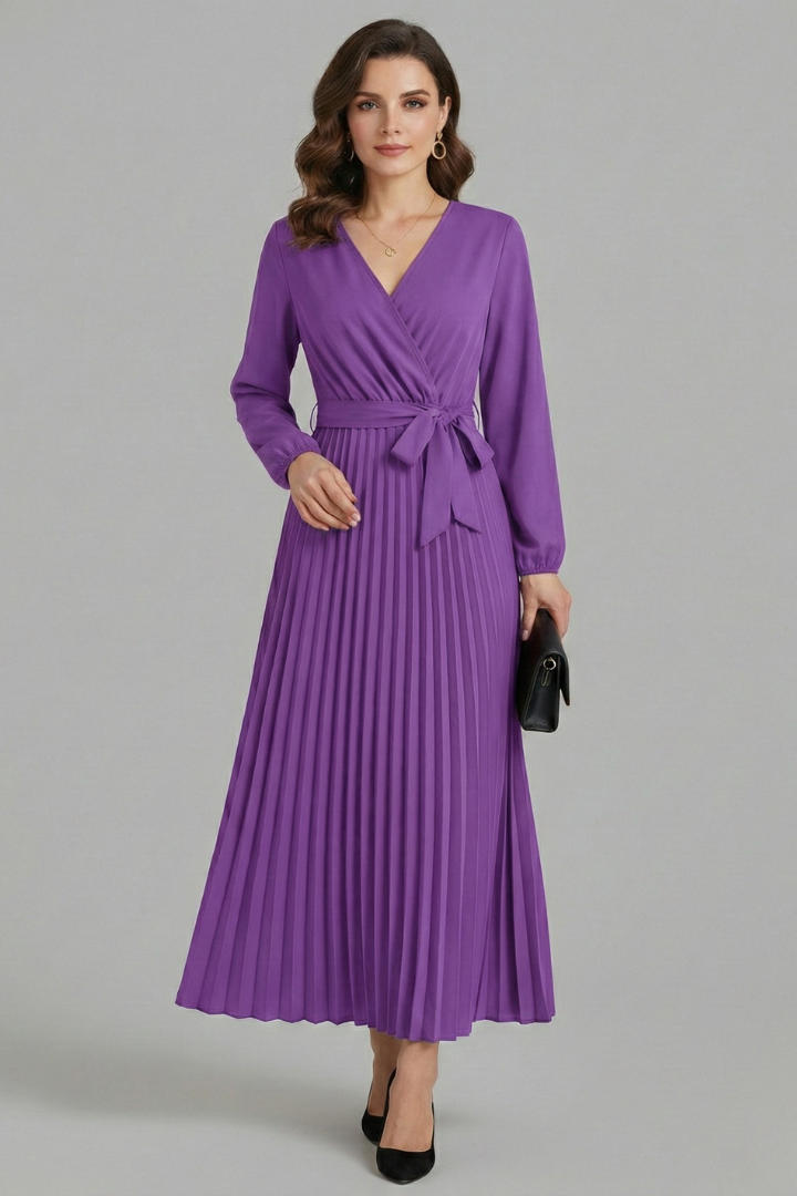 Woman wearing a V-neck maxi dress with a flowing skirt against a plain background.