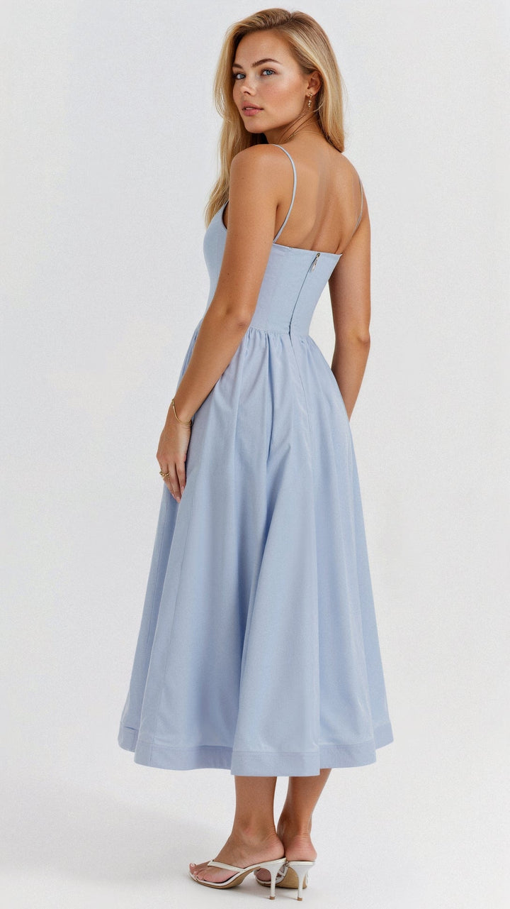 Female wearing a flowing A-line midi dress on a plain background.