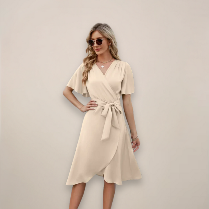Woman in a flowing midi dress with an adjustable waist tie.