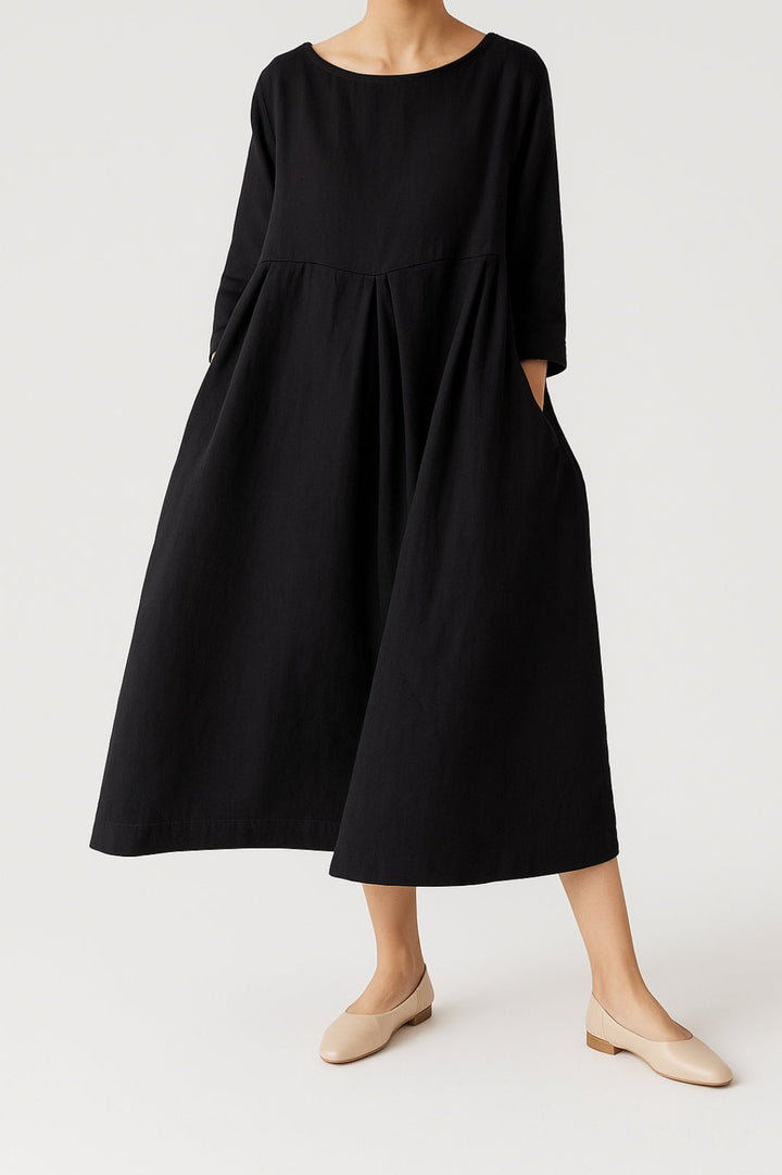  Woman in a relaxed midi dress designed for casual and smart-casual styling on a plain background.