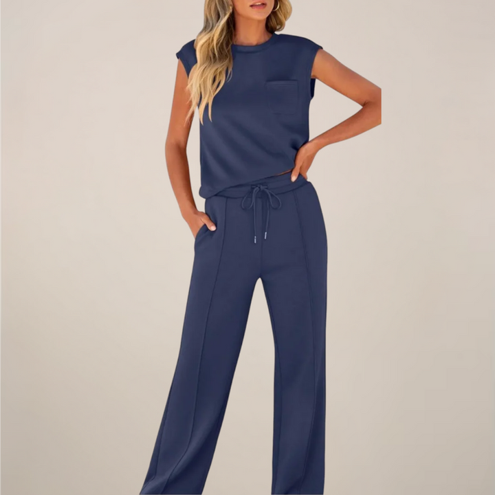 Woman in a coordinated relaxed outfit with drawstring pants on a plain background.