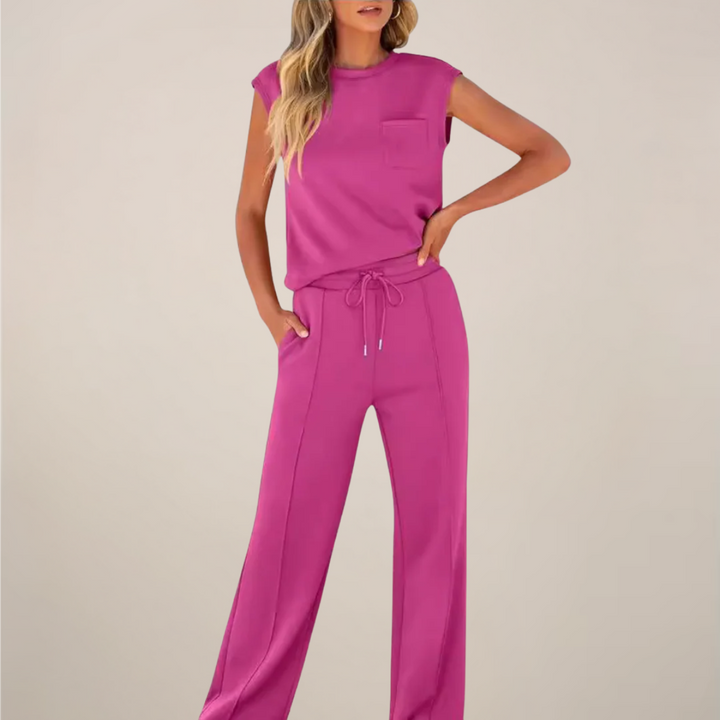 Woman showcasing a relaxed summer pants outfit on a plain background.