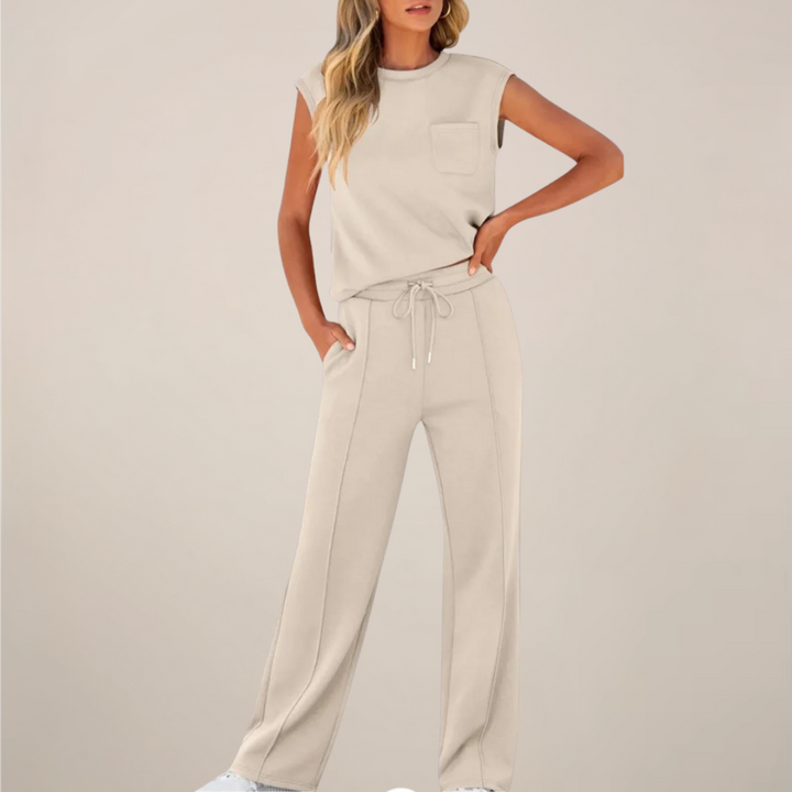 Model dressed in a relaxed pants set with simple seasonal styling on a plain background.