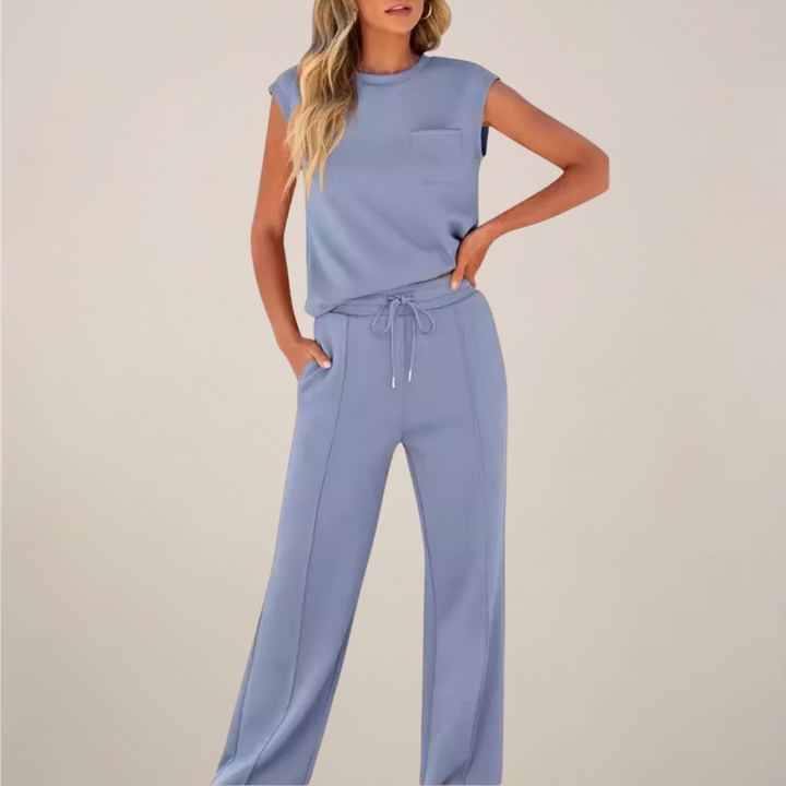Female model wearing a casual spring pants set on a plain background.