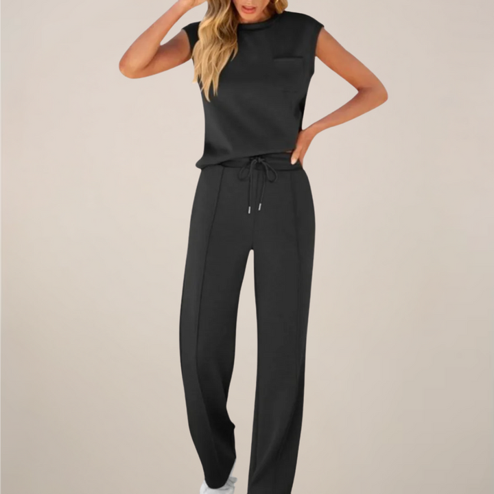 Female model wearing a relaxed drawstring pants set on a plain background.