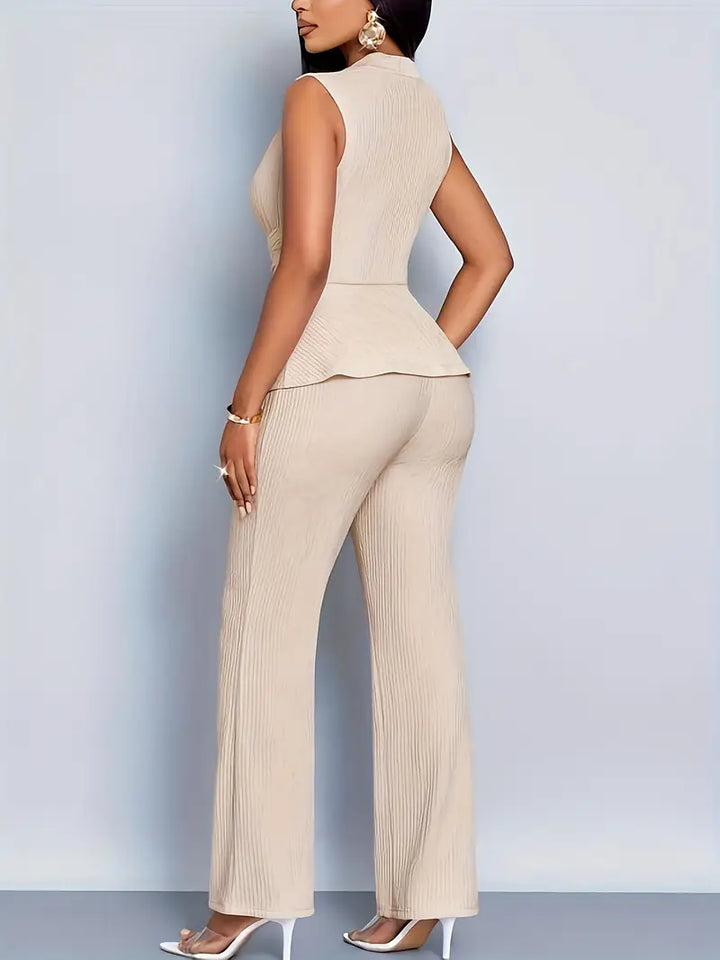 Female model in a defined-waist top and relaxed trousers against a plain background.
