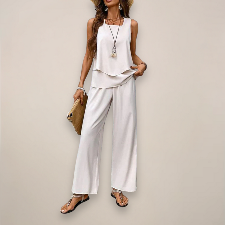 Woman wearing a printed wide leg outfit for casual warm season styling on a plain background.