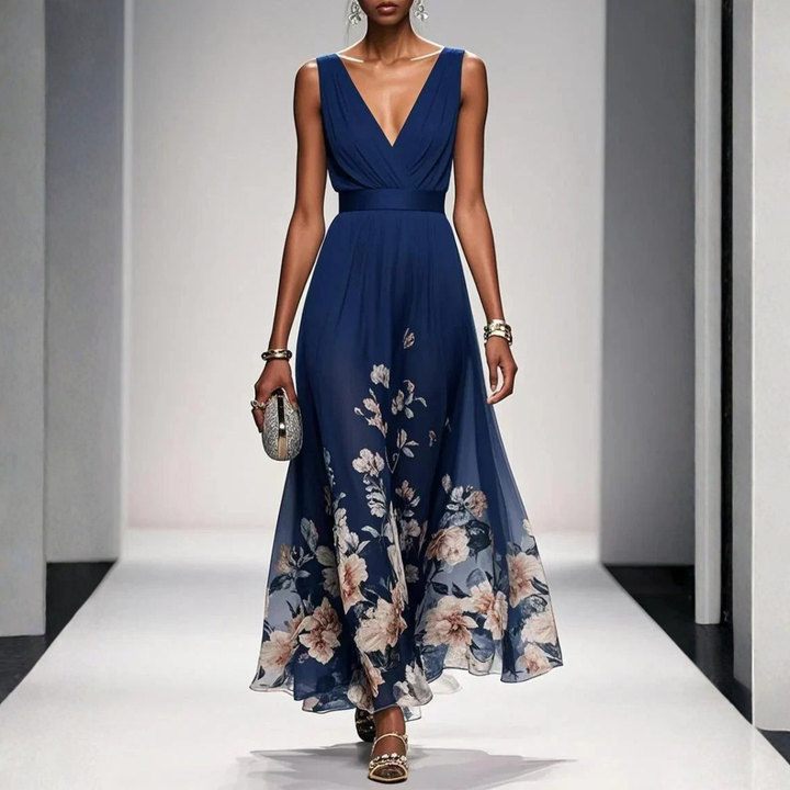 Female wearing a floral print maxi dress with flutter sleeves on a plain background.