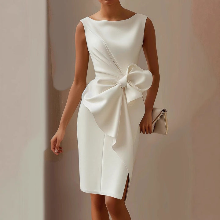 Woman posing in a fitted sleeveless midi dress with draped skirt styling on a plain background.