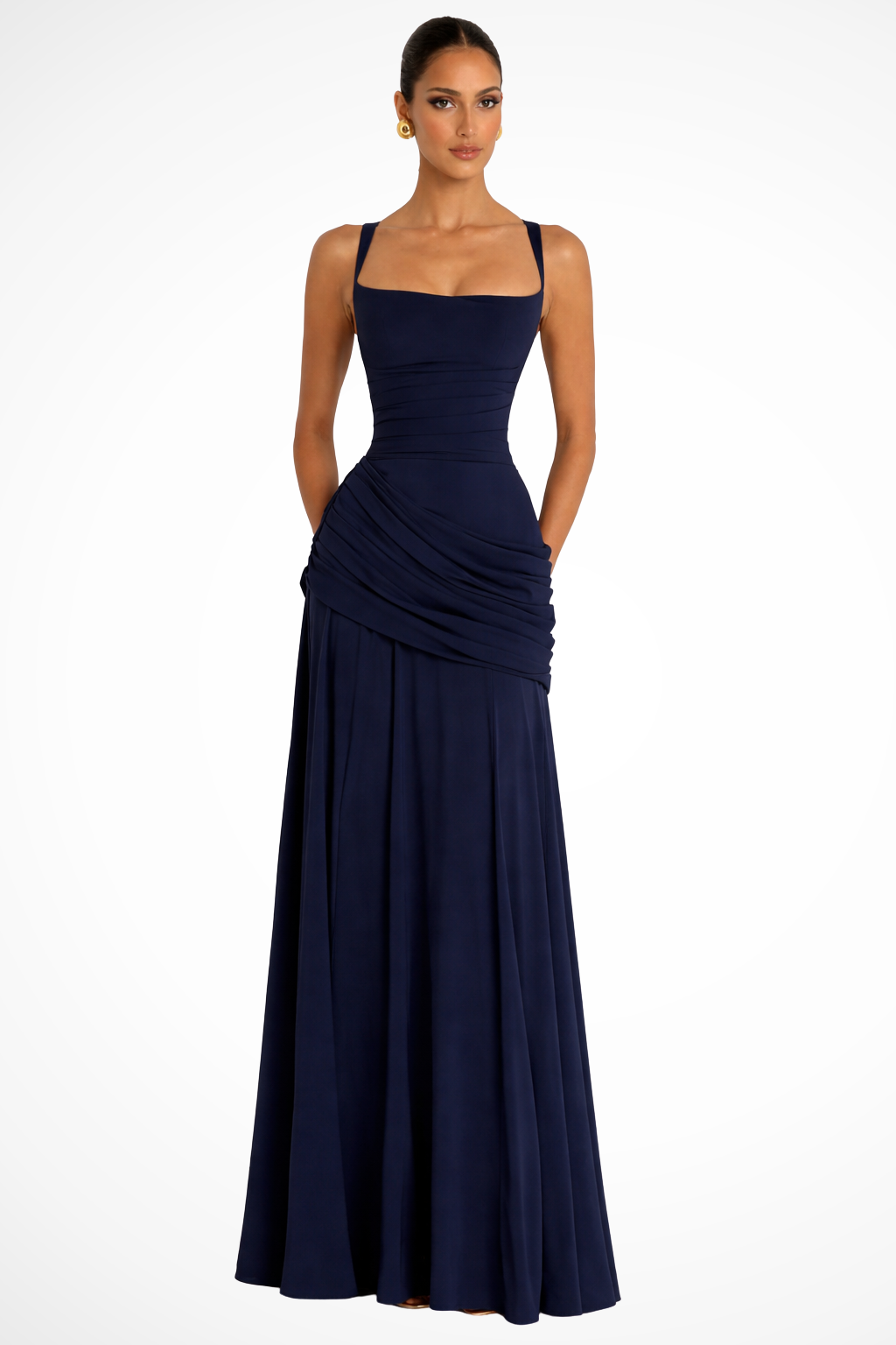 Woman wearing a long elegant dress with wide straps on a plain background.