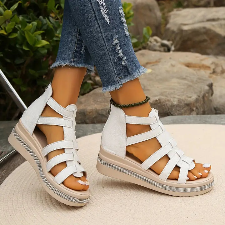 Woman in comfortable open-toe sandals against a plain background.