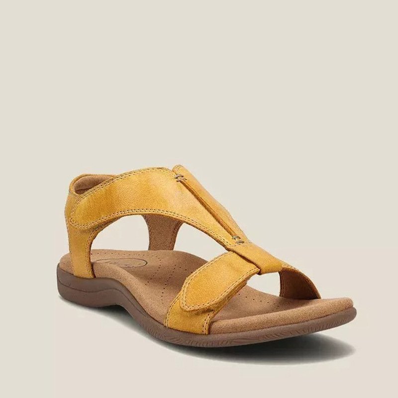 Woman showcasing comfortable casual sandals on a plain background.