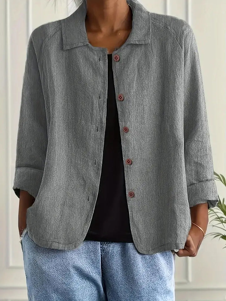  Woman wearing a timeless long sleeve top on a plain background.