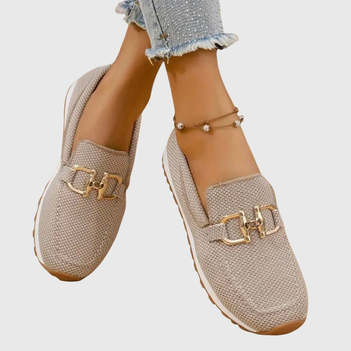 Female standing in versatile slip-on shoes against a plain background.
