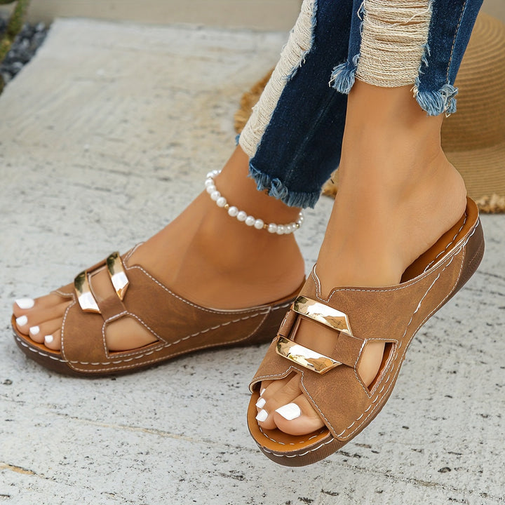 Female presenting lightweight open-toe sandals on a plain background.