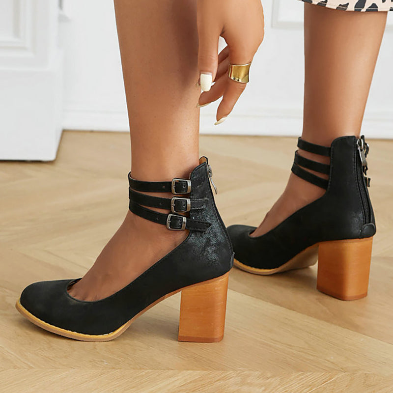 Female wearing clean strap sandals with a steady heel on a plain background.