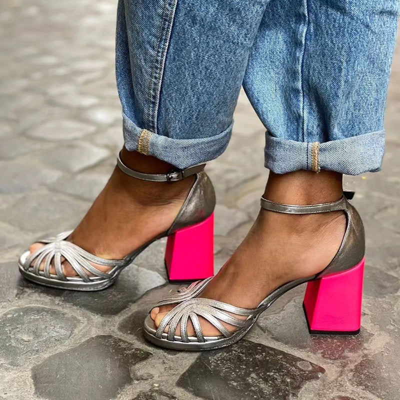 Female wearing bold fuchsia open toe block heel sandals against a plain background.