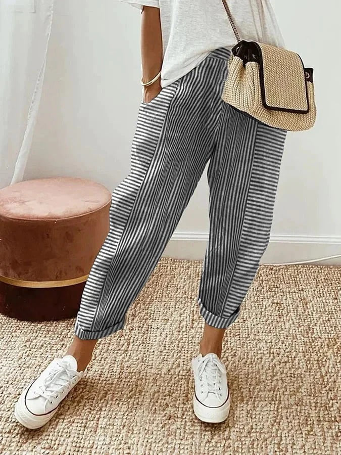 Female model displaying striped trousers with a flowing and relaxed shape.