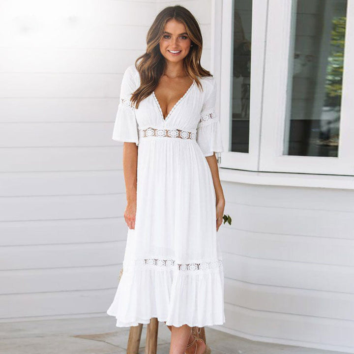 Female wearing a white midi dress with flutter sleeves against a plain background.