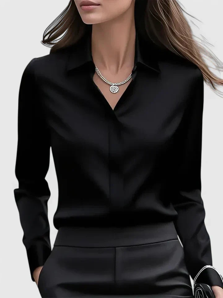  Woman wearing a collared satin shirt with a clean tailored silhouette.