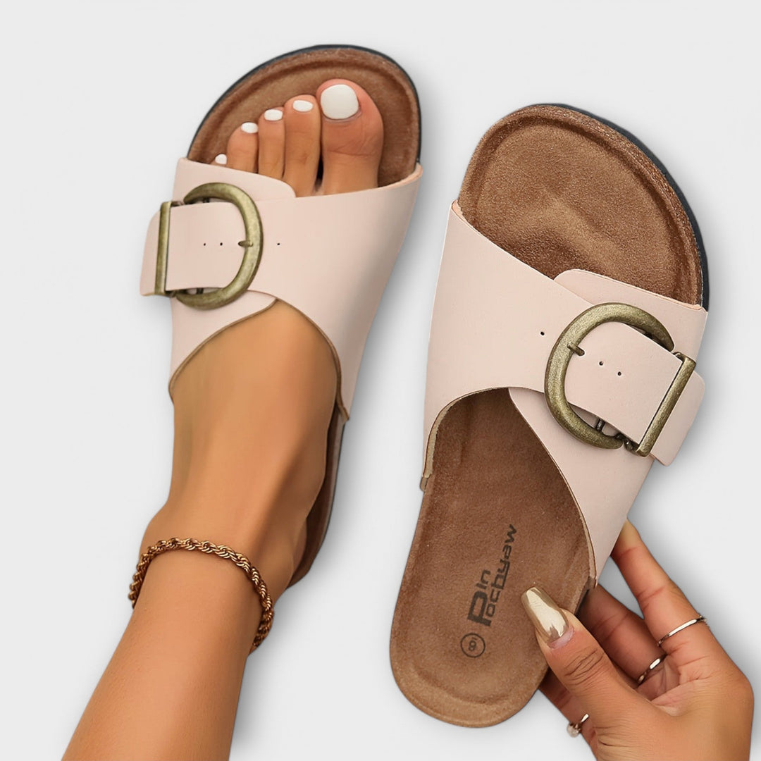 Female model wearing vintage-style sandals on a plain background.