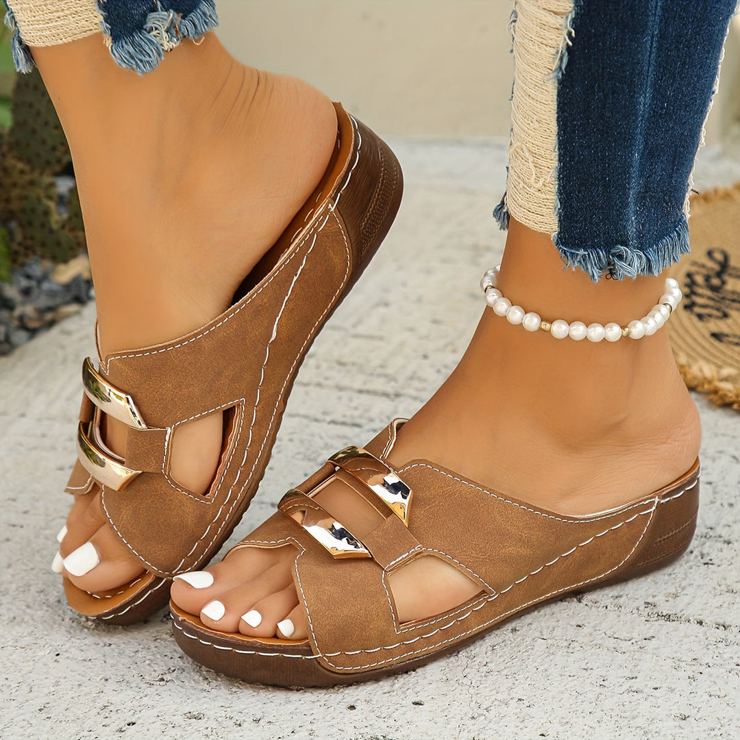 Woman standing in cushioned sandals with adjustable straps on a plain background.