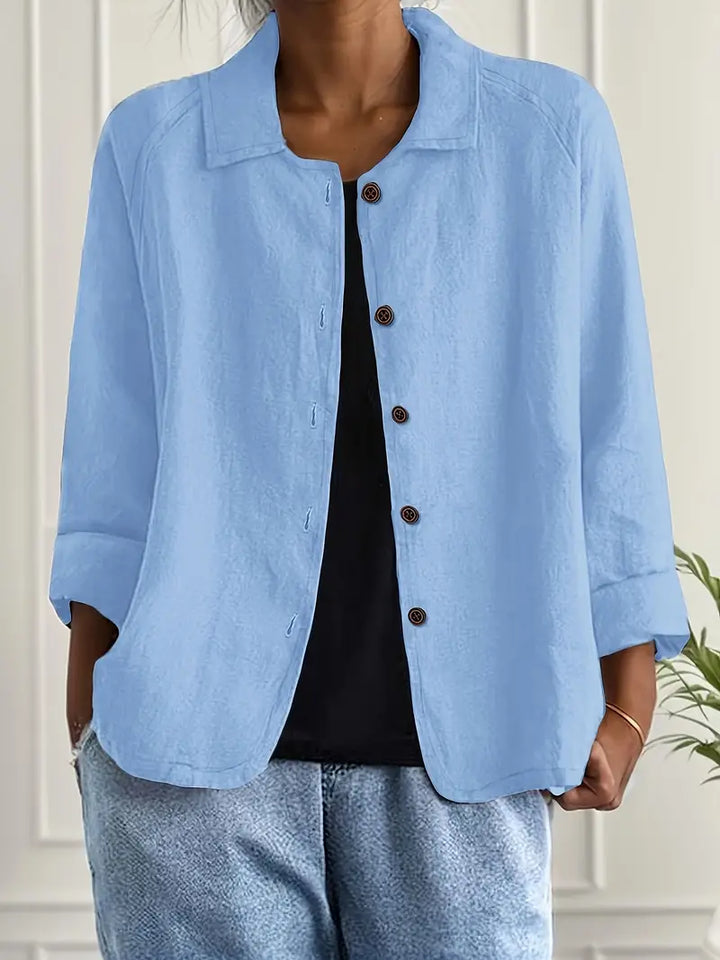 Woman wearing a lightweight layering top against a plain background.