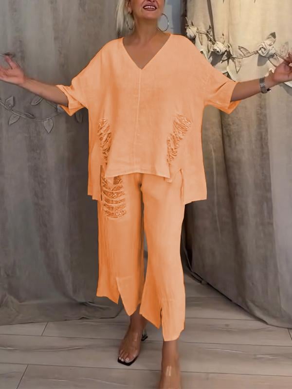 Female model wearing a relaxed V-neck top paired with flowing wide-leg trousers.