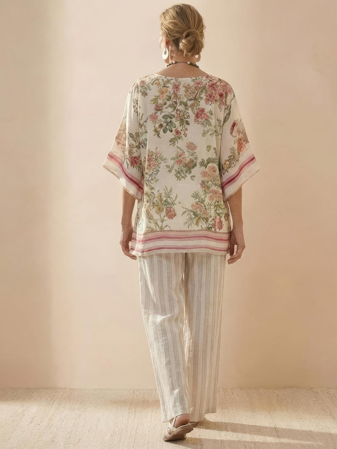 Female model wearing a relaxed-fit tunic and flowing trousers with embroidered detailing.