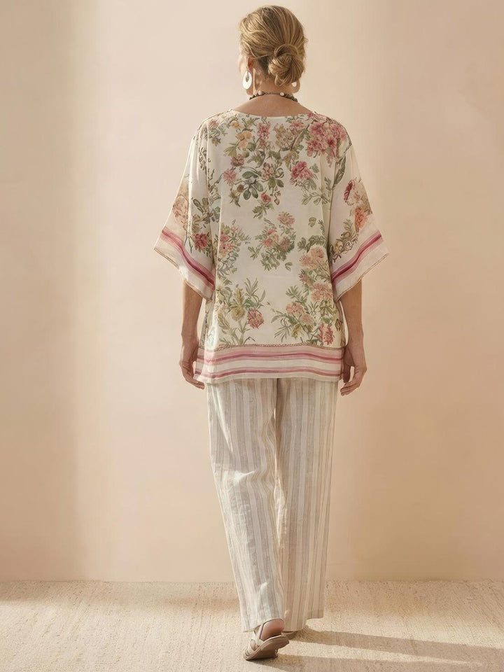 Female model wearing a relaxed-fit tunic and flowing trousers with embroidered detailing.