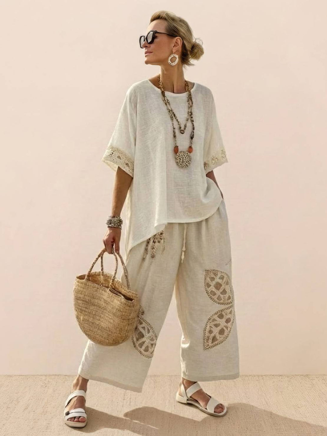 Woman in a coordinated outfit featuring embroidered trim and relaxed-fitting trousers.