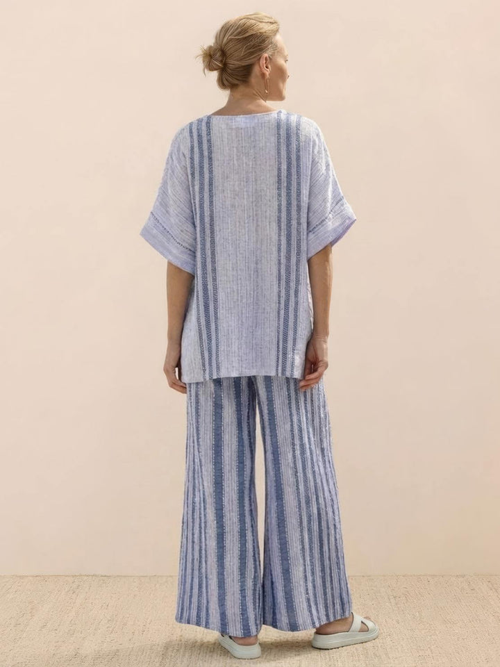 Female model in a striped embroidered outfit with a relaxed and flowing silhouette.