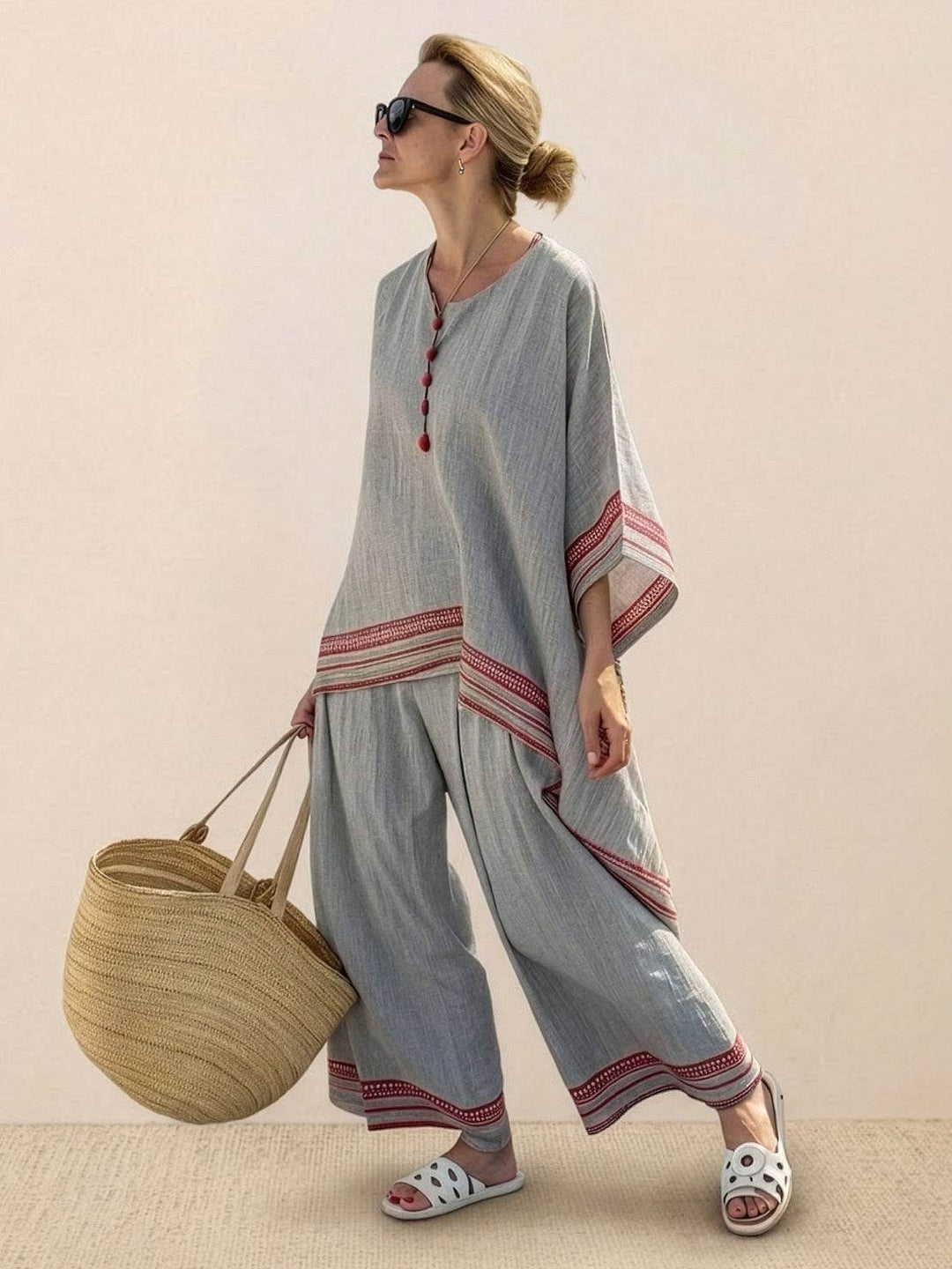 Woman styled in a two-piece tunic and trouser set against a clean plain background