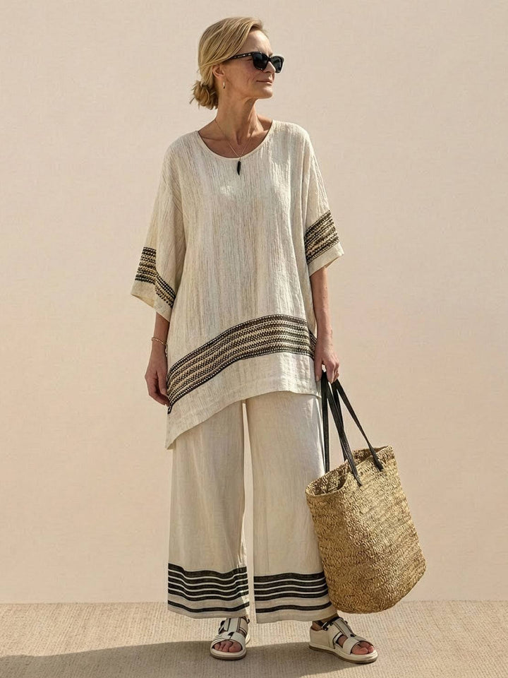 Woman styled in a coordinated embroidered set with a longline top and relaxed trousers.