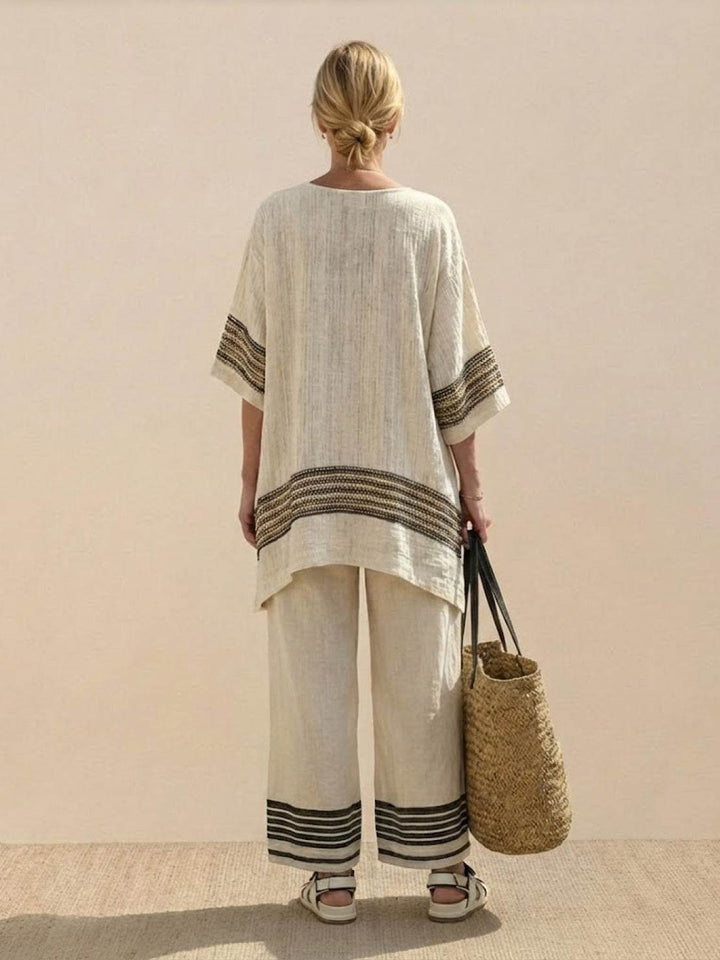 Female model wearing a striped two-piece outfit with decorative neckline and hem embroidery.