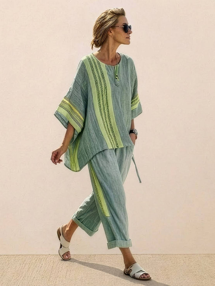 Woman in a coordinated striped outfit with floral embroidery and wide-leg trousers.