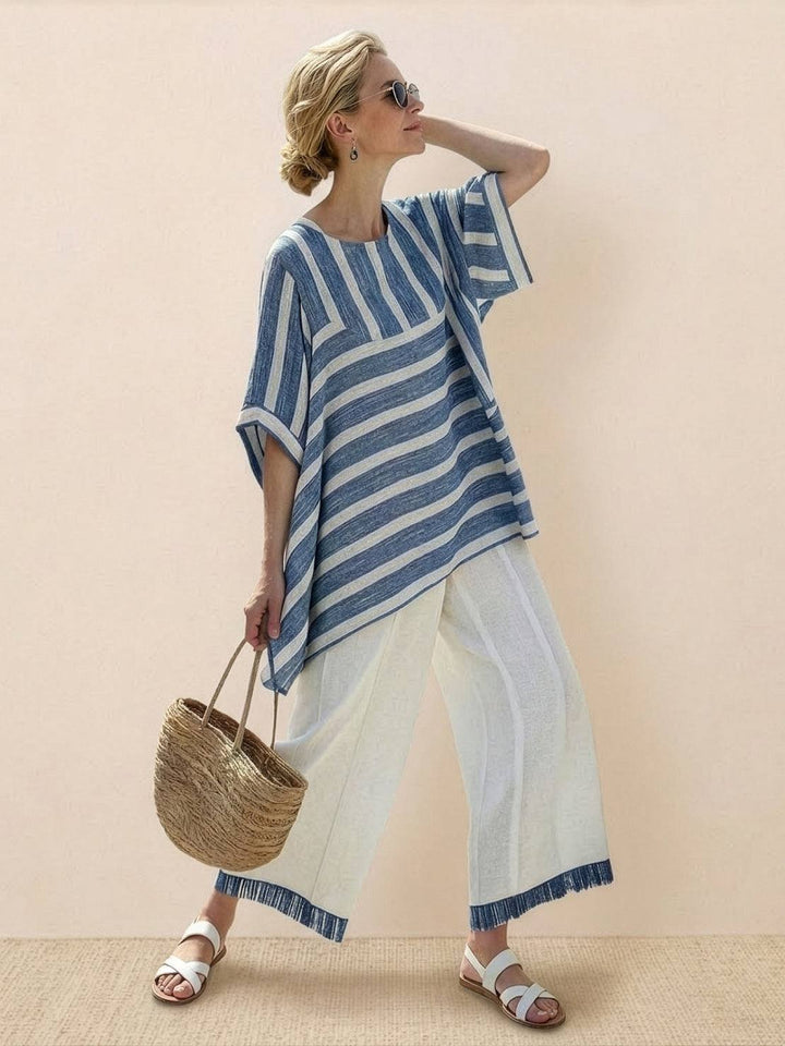 Woman in a flowing tunic and trouser set featuring embroidered floral detailing.