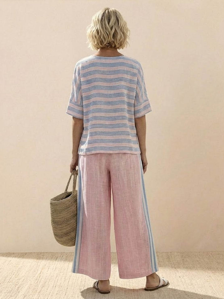 Female model wearing a striped tunic and matching wide-leg trousers against a plain backdrop.