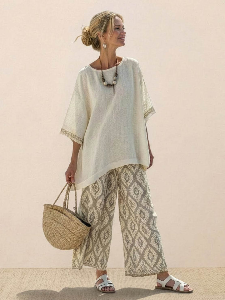 Woman wearing a striped embroidered co-ord set with wide-leg trousers on a plain background.