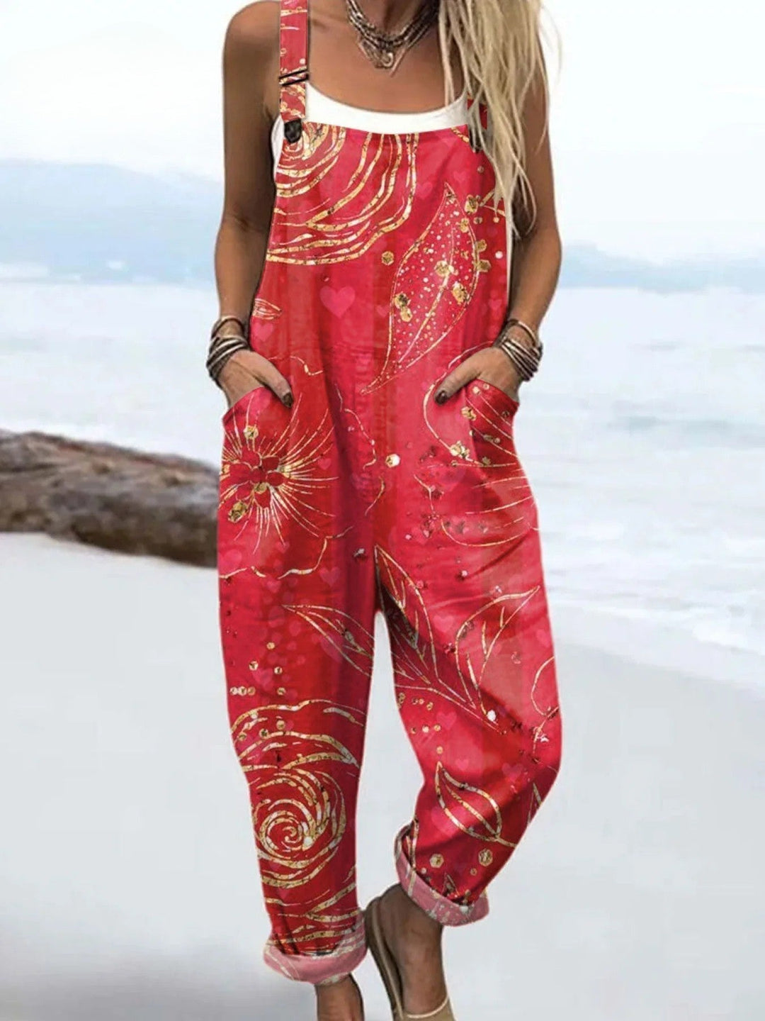 Female model wearing a flowy floral jumpsuit against a plain background.